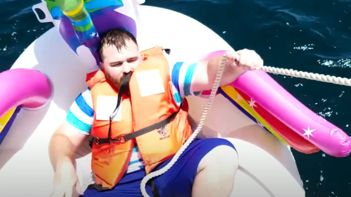 man on pool floaty at sea