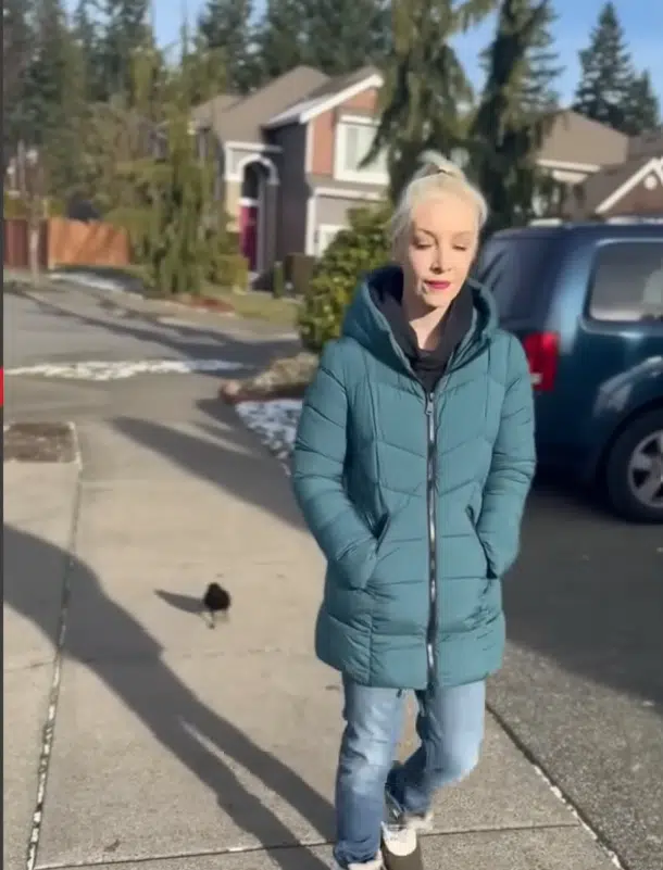 Woman walks with a wild crow