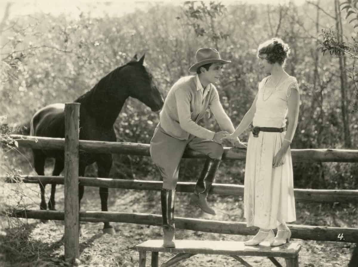 Old picture of a pet horse and a couple. 