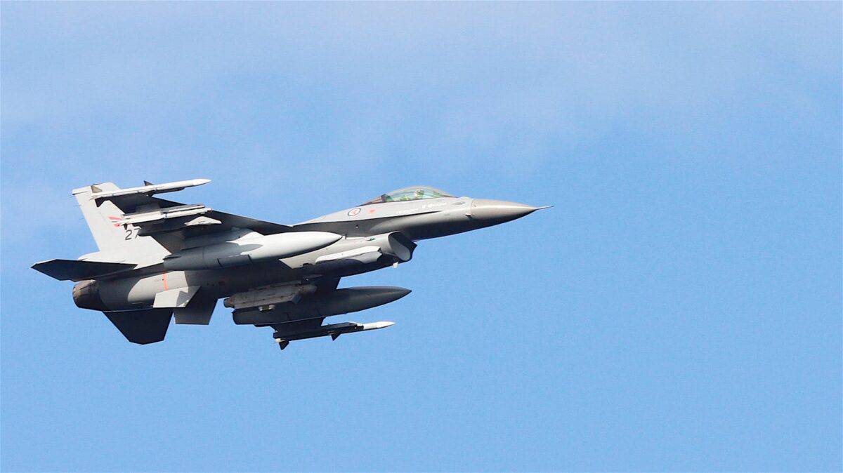 A sleek military jet aircraft soaring in a bright blue sky, illustrating aviation power.