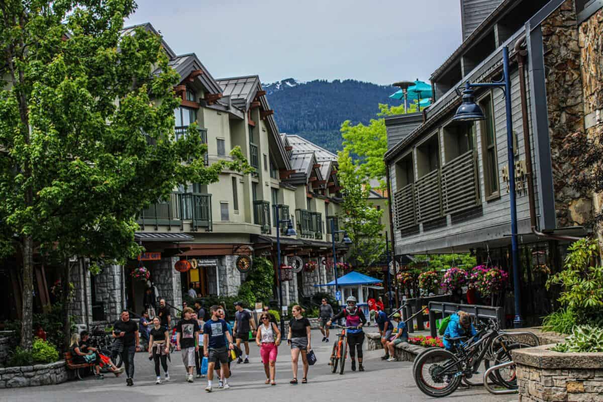 A group of people walking down a street next to tall buildings