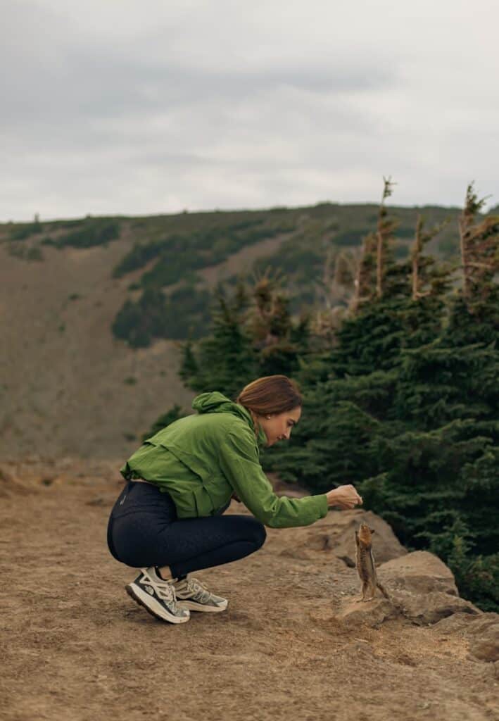 a woman kneeling down on top of a hill