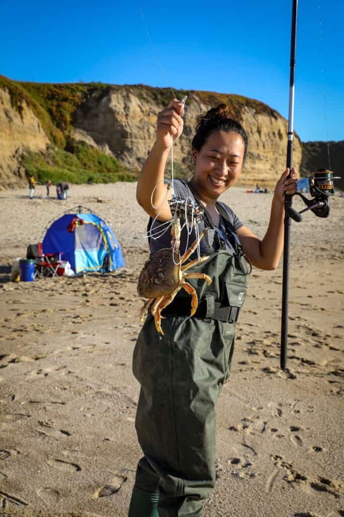 a woman holding a fish on a beach