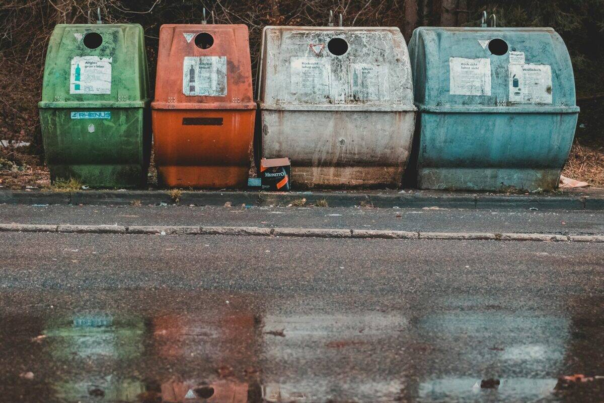 photo of four assorted-color compost pits near empty road