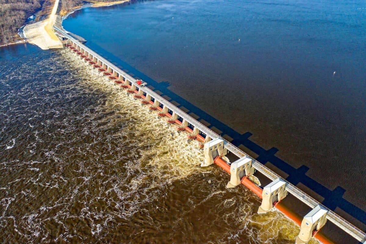 Drone shot capturing the Alma Dam's architectural structure on the Mississippi River in daylight.