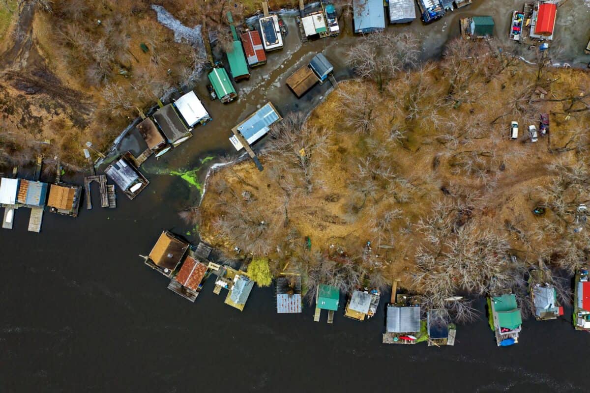 Drone shot capturing rustic cabins along the riverside in Winona, MN during early spring.