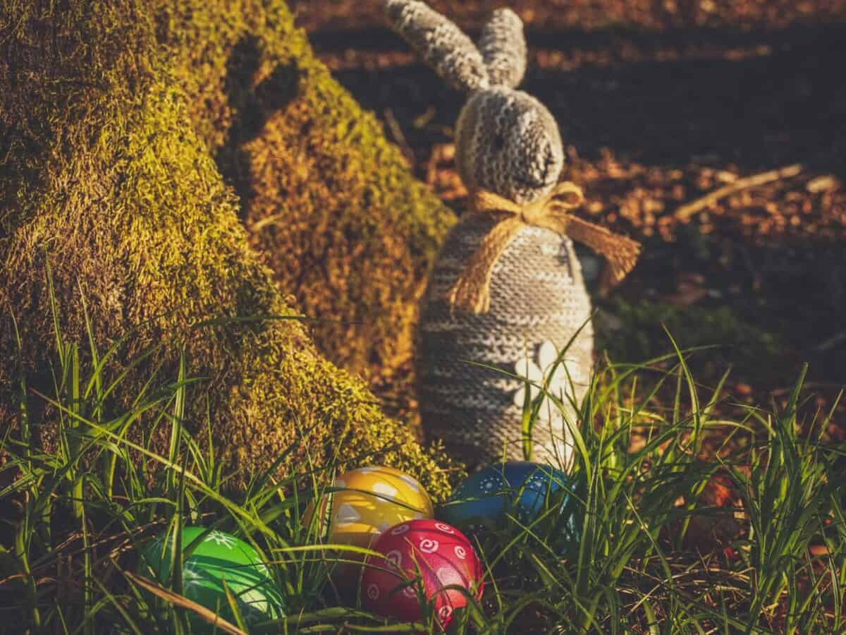 A charming Easter scene with colorful eggs and a rustic bunny in a natural outdoor setting.