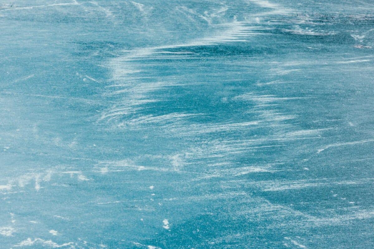 Close-up of frozen lake in Qiqihar, China showing intricate natural patterns on ice surface.