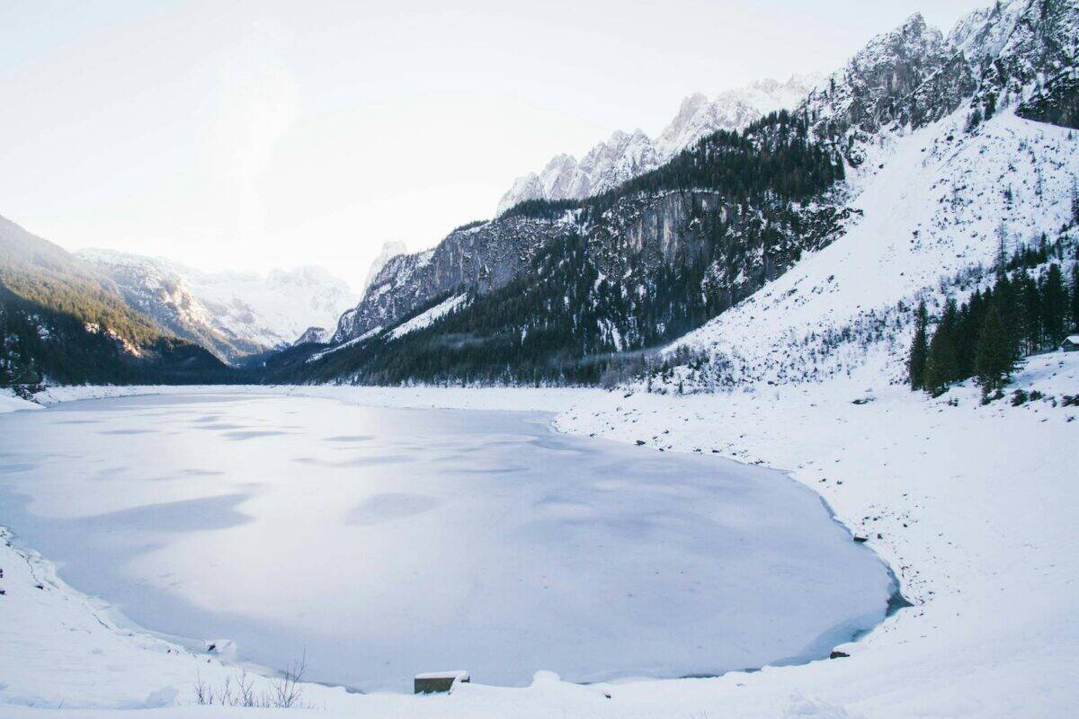 Frozen lake surrounded by snow-capped mountains in Liezen, Austria.