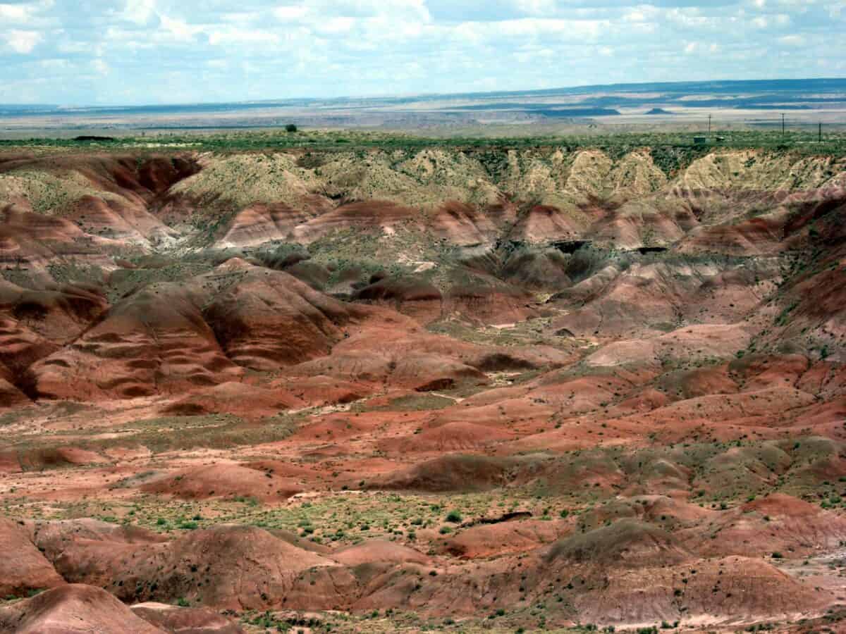 A breathtaking aerial view showcasing the colorful hues of Arizona's Painted Desert under a vibrant sky.