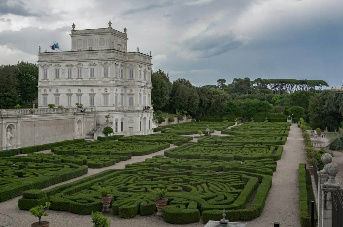a large white building with a large garden in front of it