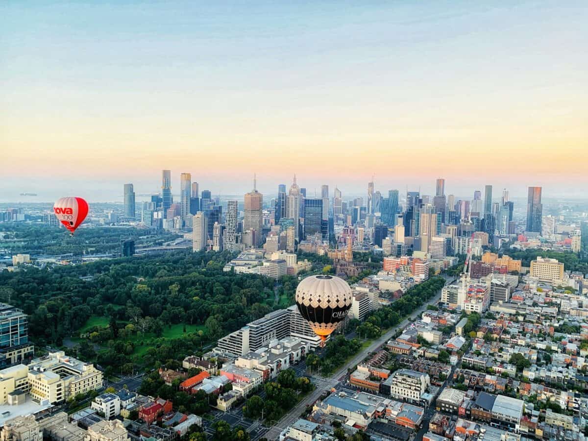 hot air balloons over city buildings during daytime