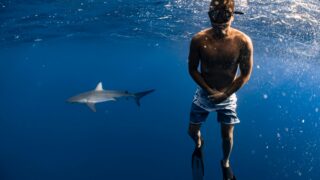 A man having a photo taken with a shark.
