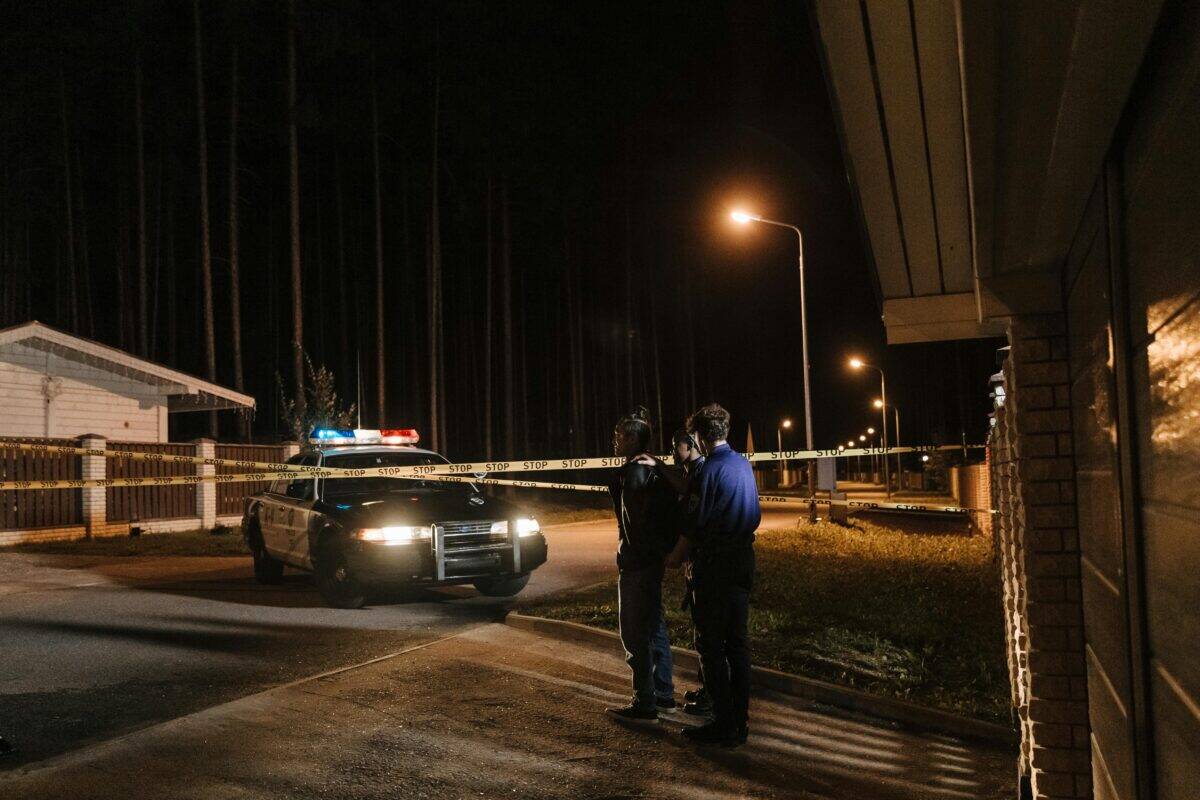 Authorities and a police car parked in a residential area.