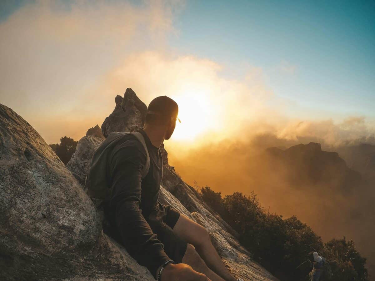 A hiker trying to view the sunset uphill.