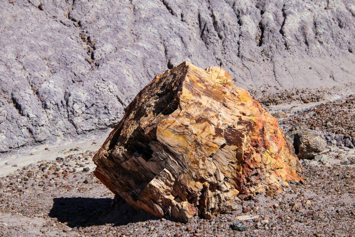 A large rock sitting in the middle of a desert