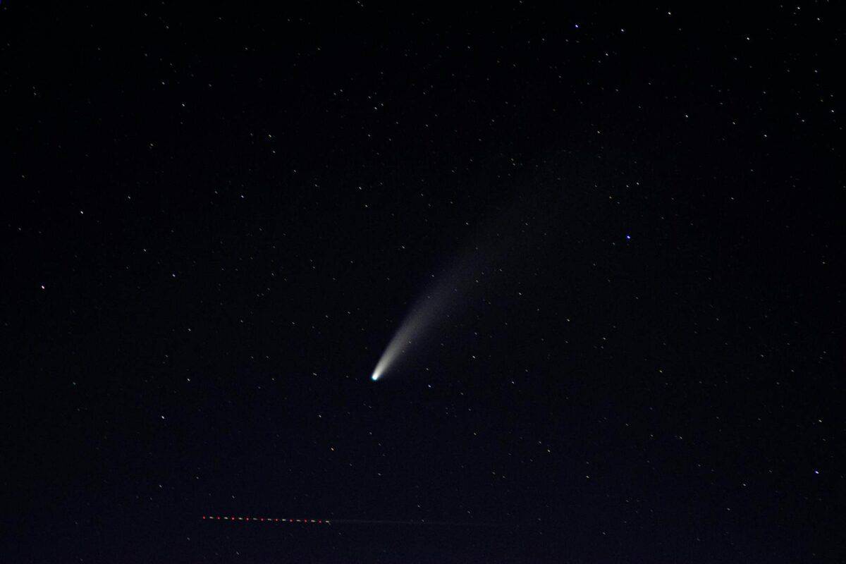 Captured under Airolo's night sky, a bright comet and stars create a celestial spectacle.