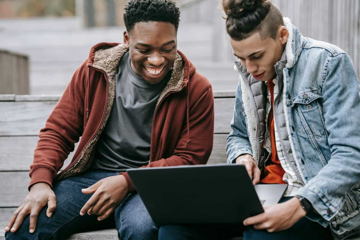 Two guys watching something on a laptop.