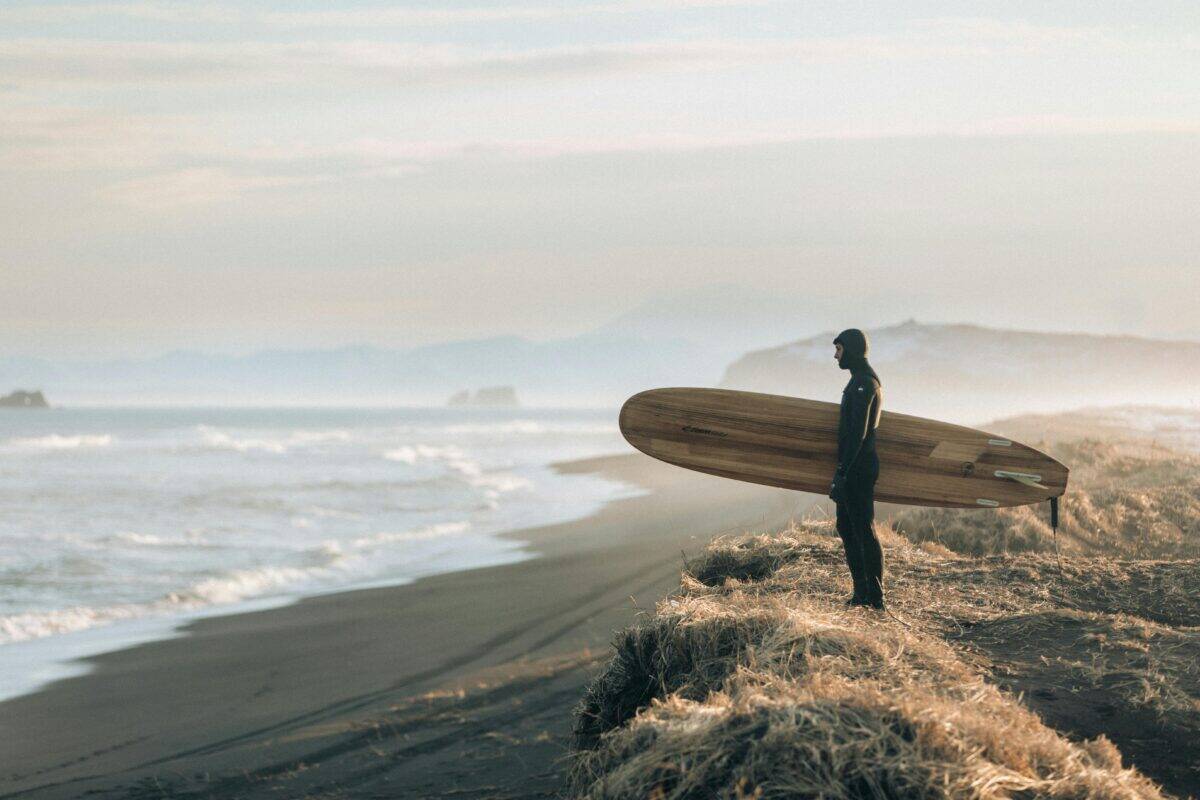 A surfer holding his board at the shore.