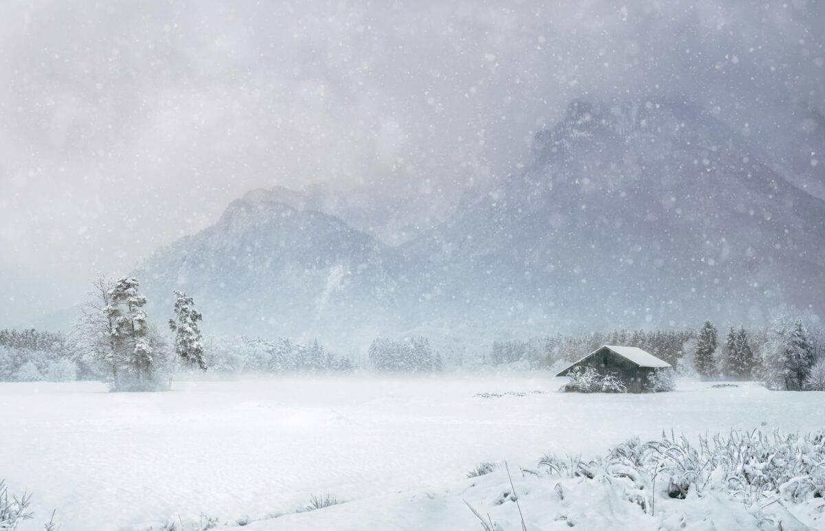 house covered with snow near mountain