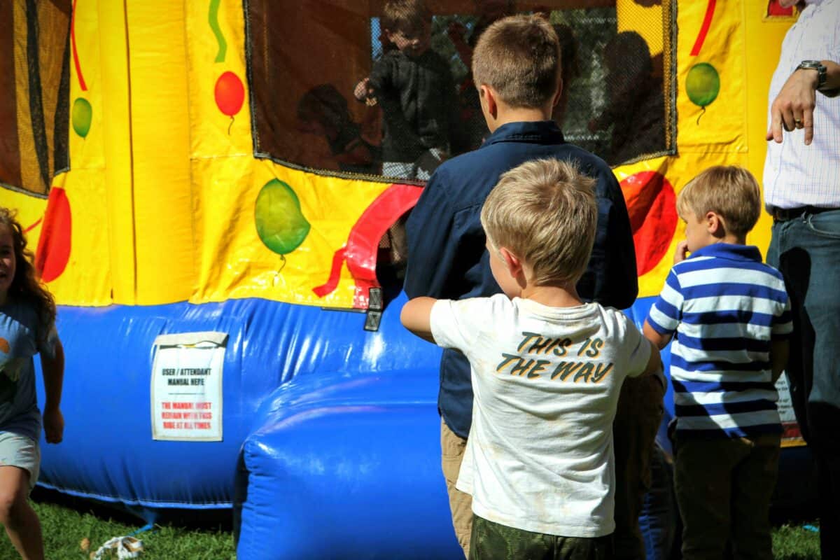 Children enjoying a big inflatable playhouse at a party.