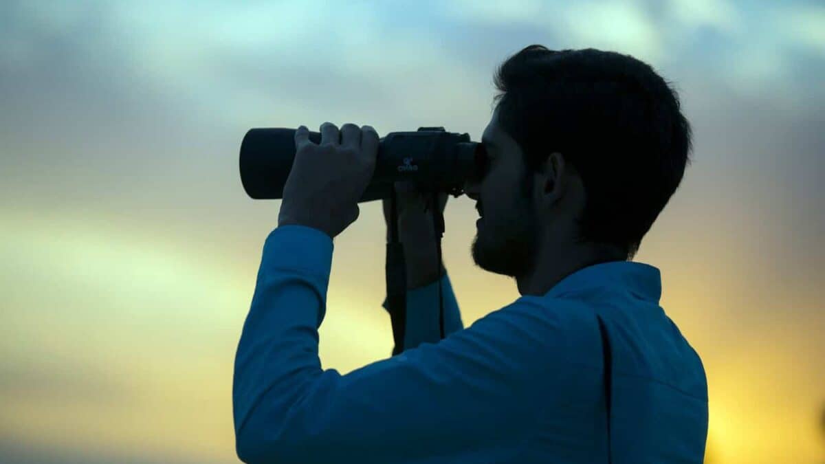 man holding telescope