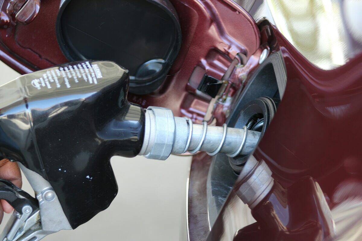 A person loads some fuel into the vehicle.