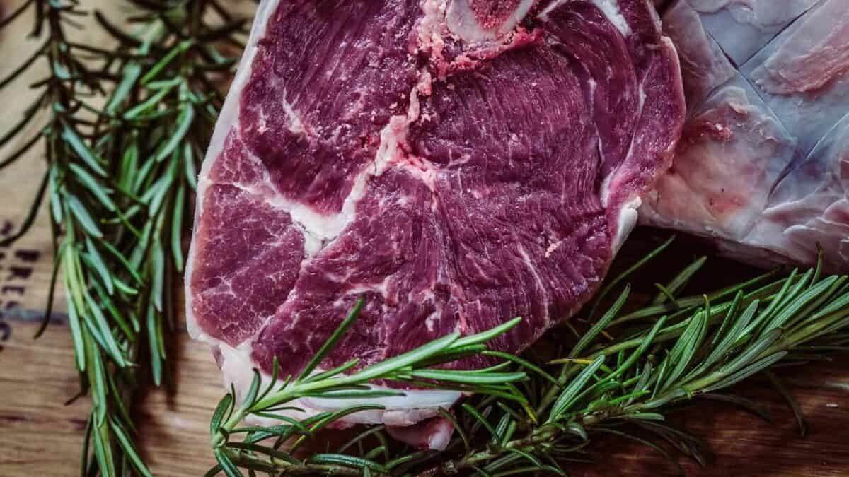 raw meat and green leaf plant on brown surface