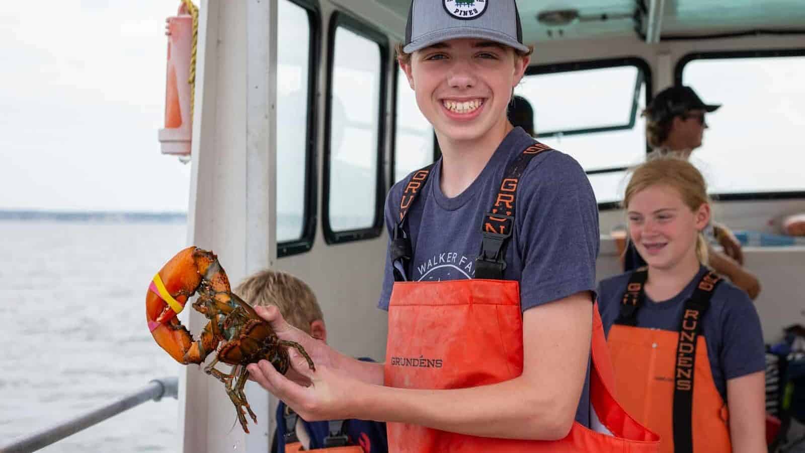 a boy holding a crab on a boat