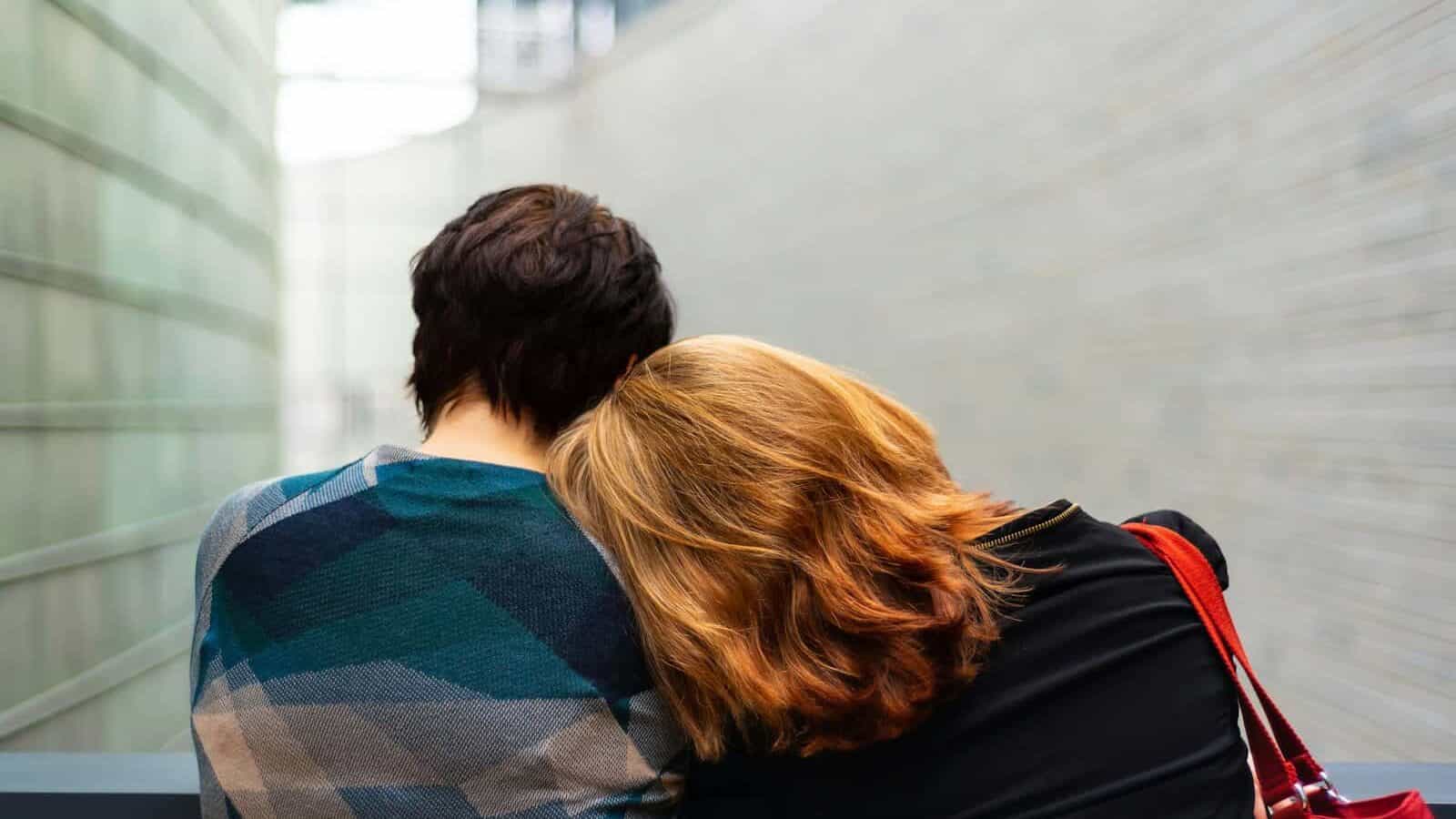 a woman rests her head on another person's shoulder