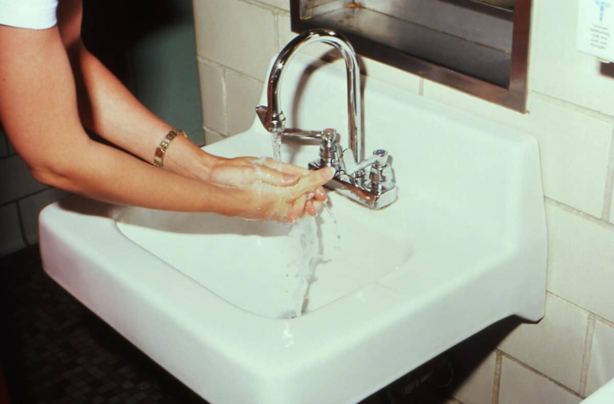 A woman washing her hands.
