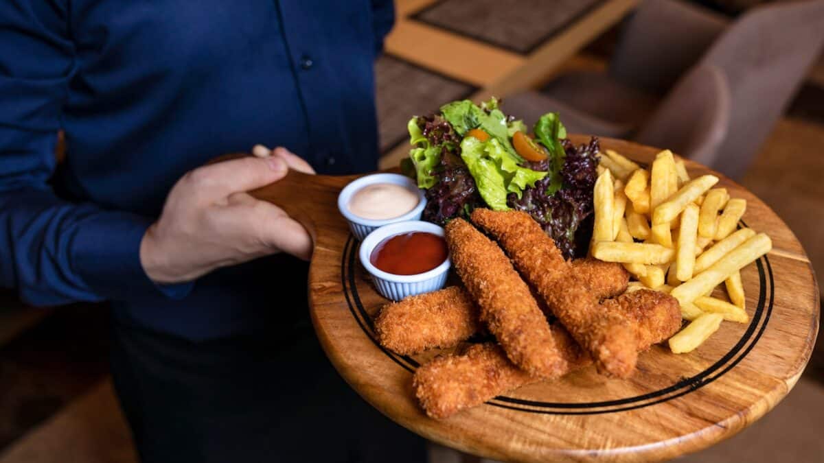 fried food with green vegetable on brown wooden round plate