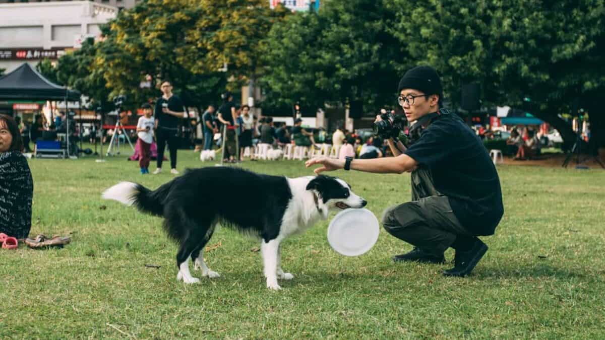 man holding black and white dog