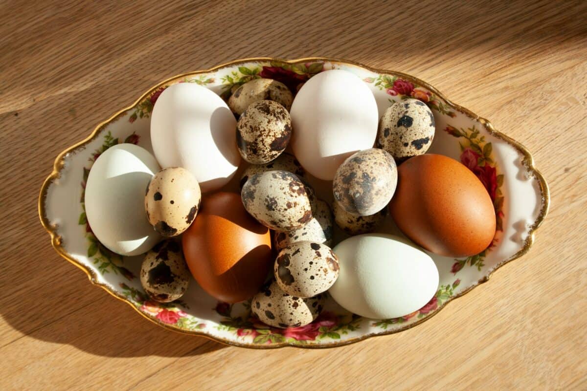A bowl filled with eggs on top of a wooden table