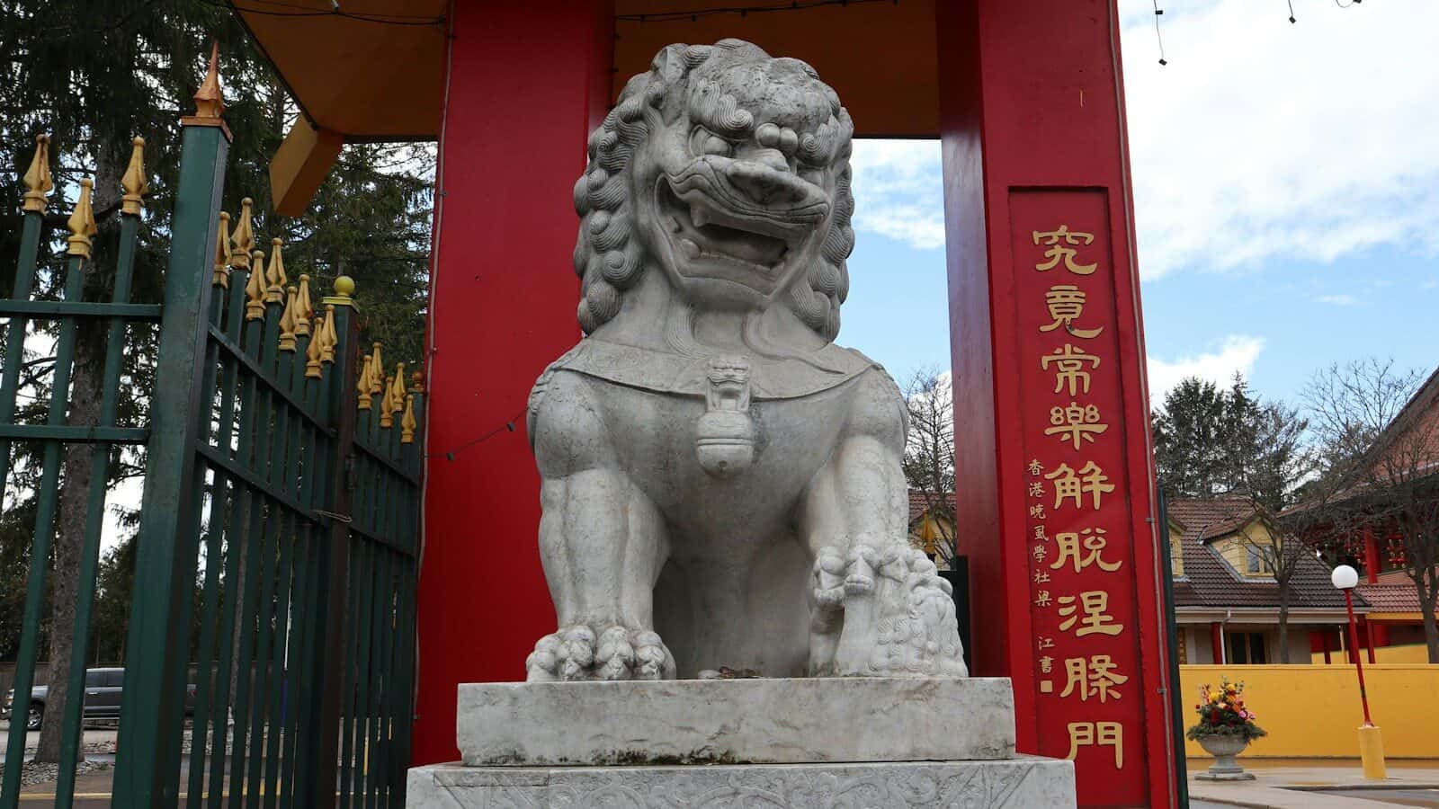 a statue of a lion in front of a gate