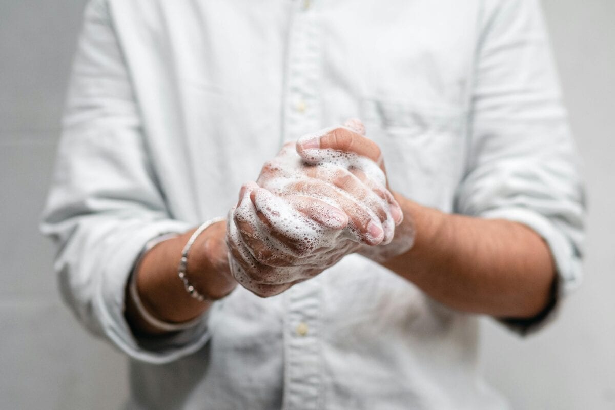 A man rubbing his hands with soap lather.