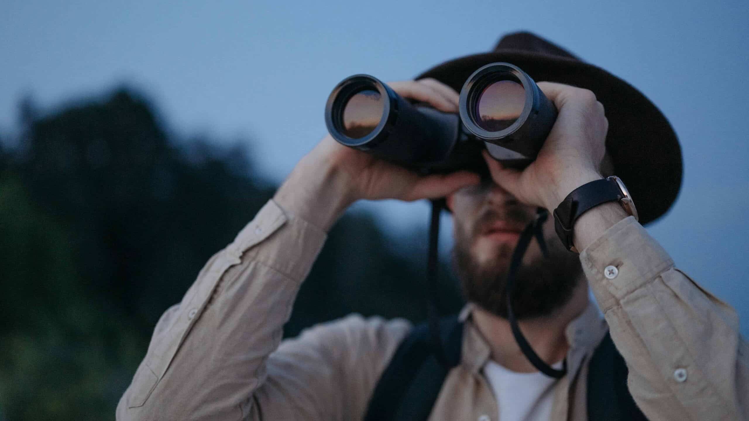 A man peeking at his binoculars.