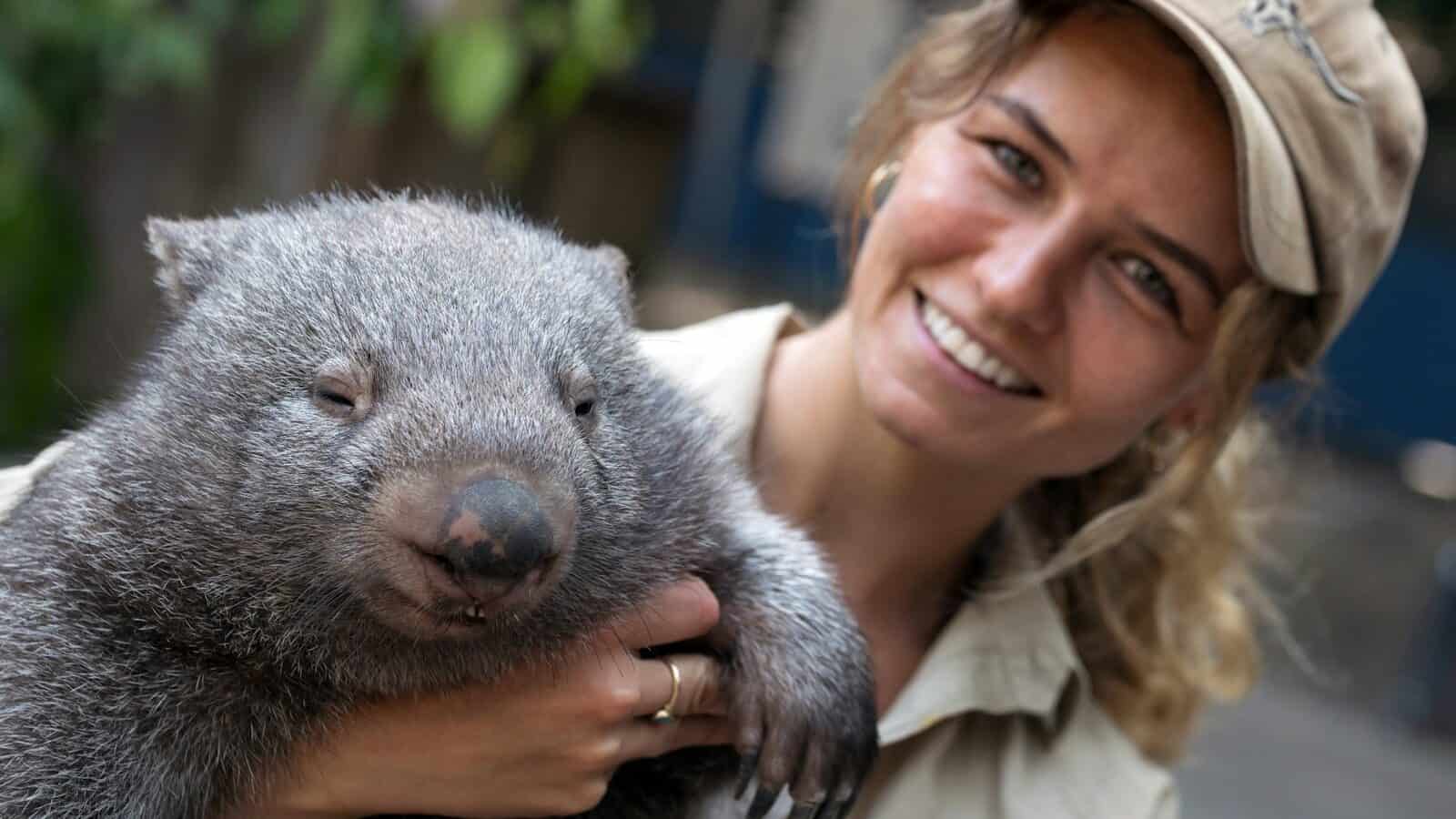 girl in white shirt holding gray animal