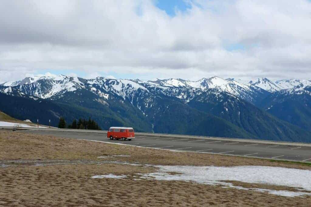 yellow Type B motorhome on road near mountain under cumulus