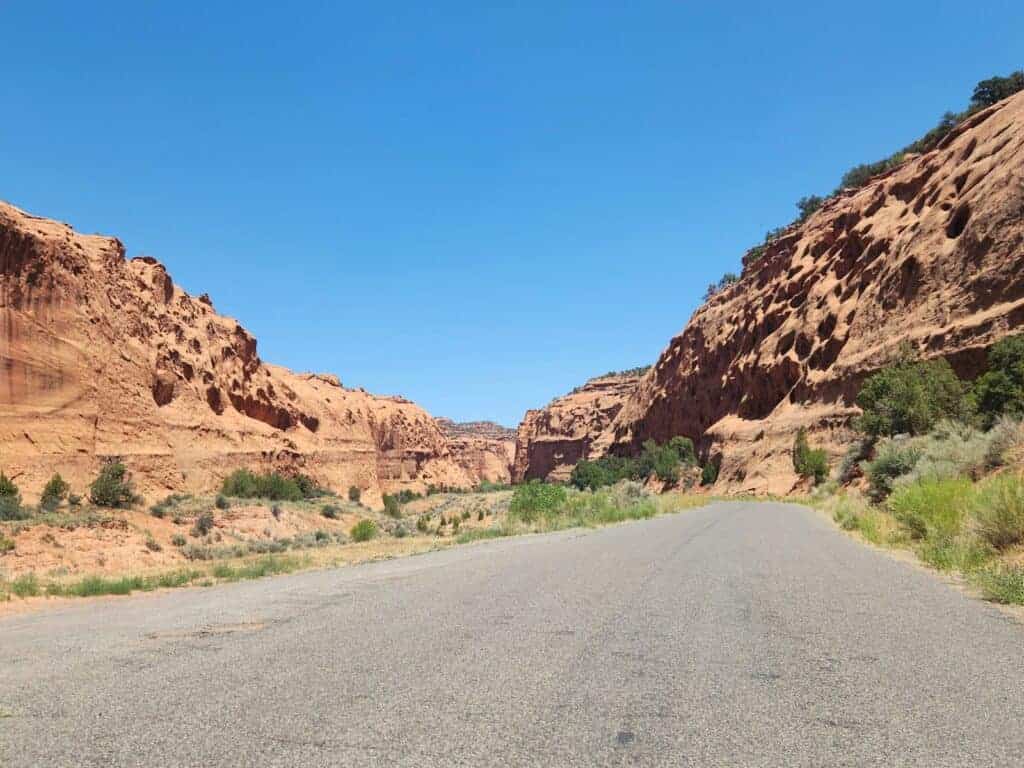 A road in the middle of a desert with a mountain in the background