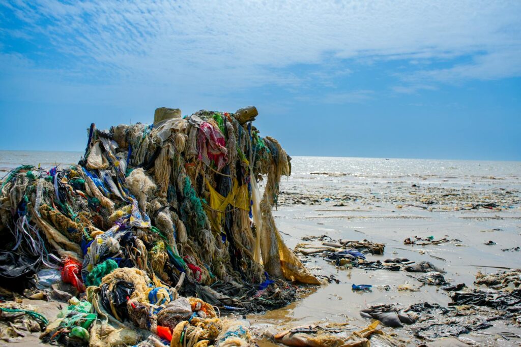 Plastic waste and debris on Freetown's beach in Sierra Leone, highlighting environmental pollution.