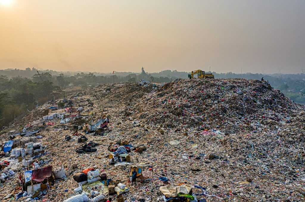 Aerial shot of a large landfill with garbage piles, showcasing waste management challenges.