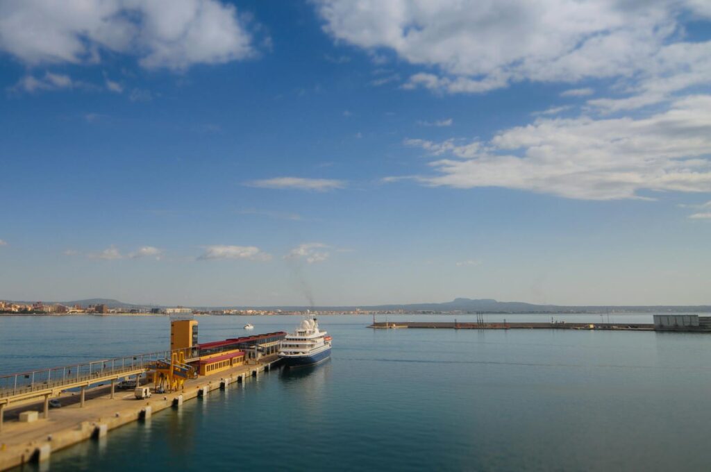 A beautiful scene of a ship docked at a pier with a clear sky over the harbor.