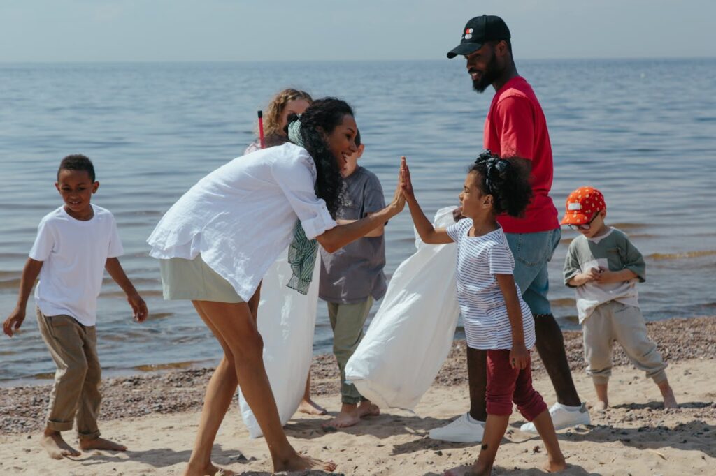 woman doing a high five for a kid in a beach cleanup