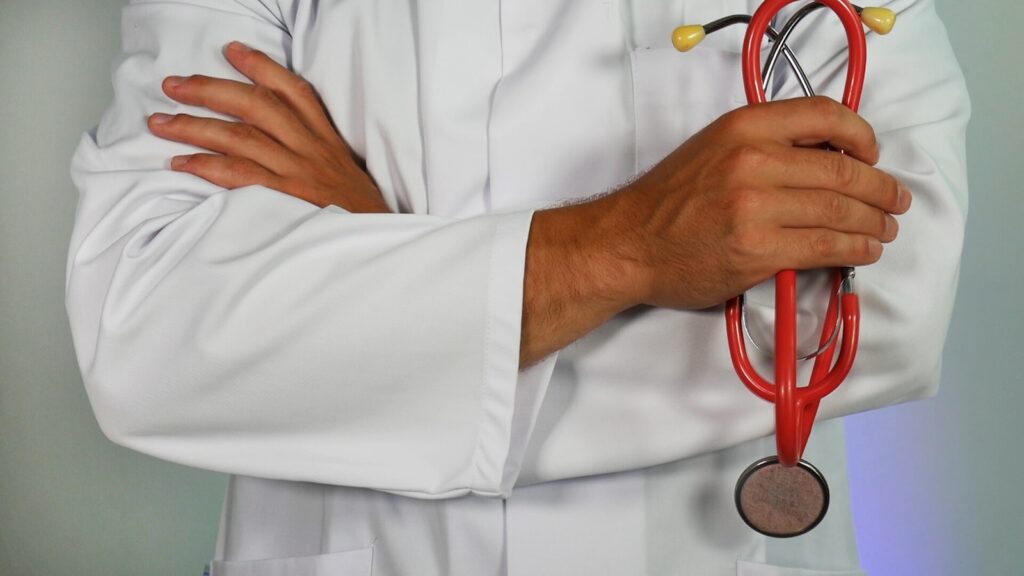 A doctor holding red stethoscope.