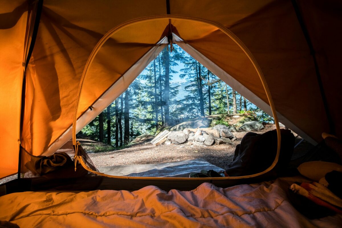 Inside a tent, featuring soft fabric walls and a view of nature through the open flap.